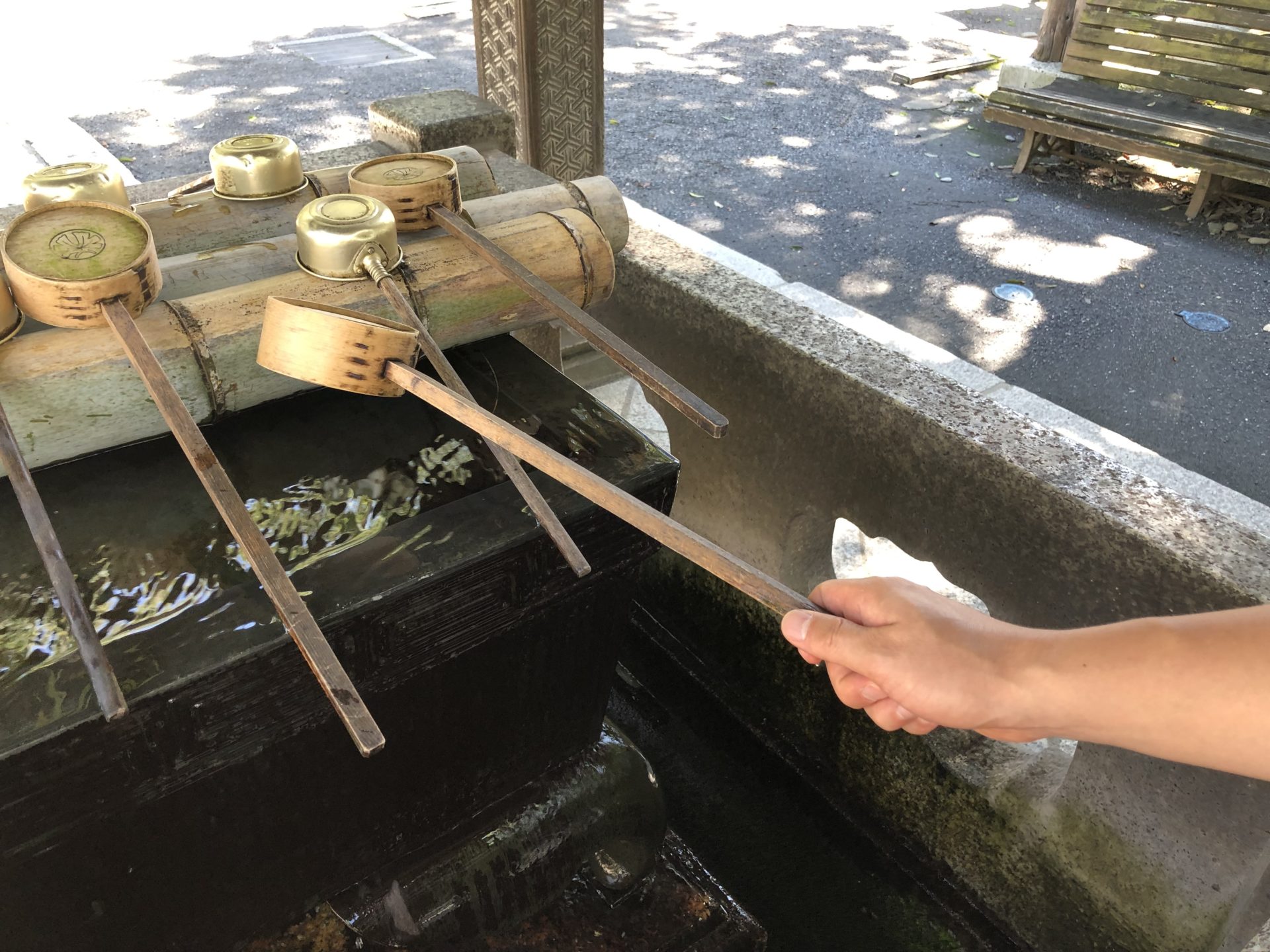 右手で柄杓を持って水を汲む